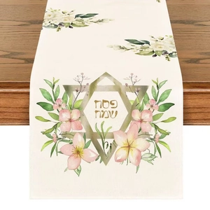 Close-up of linen table runner with floral patterns and gold Star of David for Passover