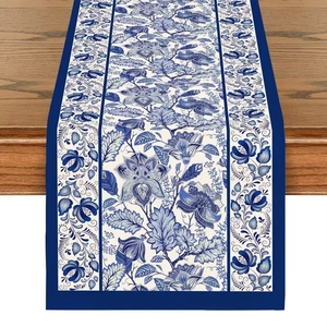 Blue and white porcelain style linen table runner with floral pattern on dark wood surface