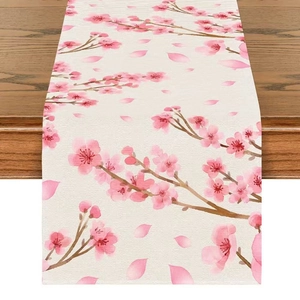 Linen table runner detail showing pink cherry blossom print on woven fabric texture
