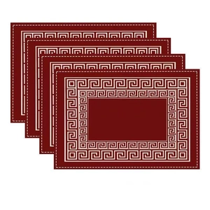 Close-up of four red bohemian placemats with white Greek key patterns and stitched edges