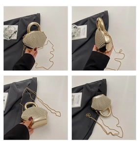 Dettaglio di una borsa da sera dorata a forma di conchiglia con texture borchiata
