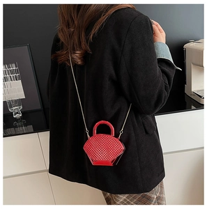 Dettaglio mini borsa rossa trapuntata con tracolla a catena indossata da una modella