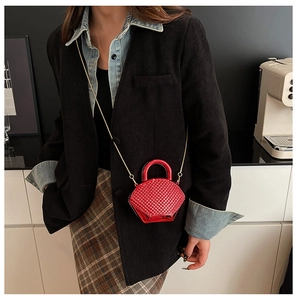 Primo piano della mini borsa in acrilico rosso con strass e catena dorata su modella