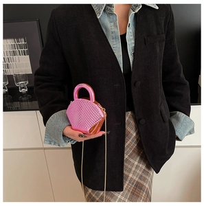 Dettaglio mini borsa rosa con strass scintillanti, manico in metallo e catena d'oro