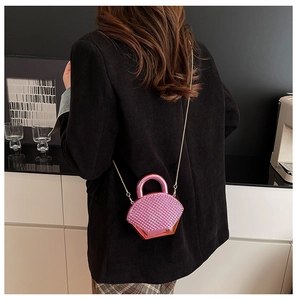 Vista modella della mini borsa rotonda rosa metallizzato con trama trapuntata e catena