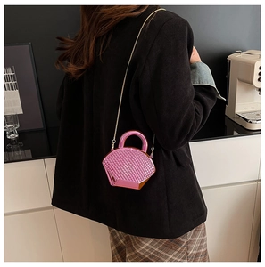 Dettaglio mini borsa rosa metallizzato con trama intrecciata e catena d'oro su modella