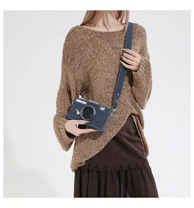 Model wearing dark blue vintage camera-shaped crossbody bag with silver hardware