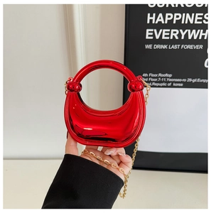 Detail of red crescent moon mini bag with round handle and gold chain strap