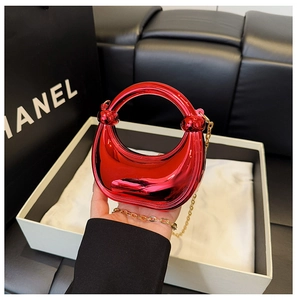 Close-up of red mirror finish mini bag with metallic texture and gold chain strap