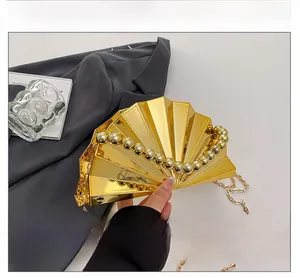 Detailansicht der goldenen Abendtasche in Fächerform mit Perlengriff und Kette