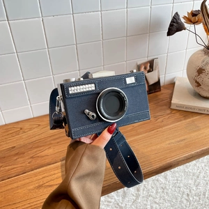 Chic blue denim camera-shaped crossbody bag with white stitching and silver hardware