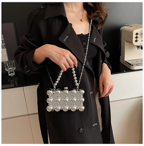 Detail showing the silver metallic evening clutch with 3D sphere texture and beaded handle