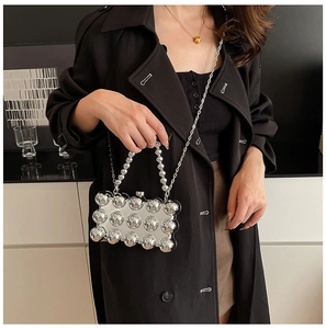 Detail of silver mirrored mini bag with 3D metallic spheres and elegant bead handle