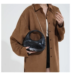 Detail of marble pattern acrylic handbag with hollow handle and gold metal chain