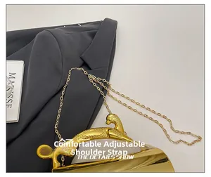 Detail of golden panther-shaped handle and metal chain on luxury acrylic evening bag