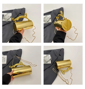 Detailed view of cylindrical gold mirror evening bag with decorative leopard handle