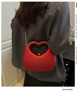 Detail of red heart-shaped acrylic evening bag with gold chain and matte finish