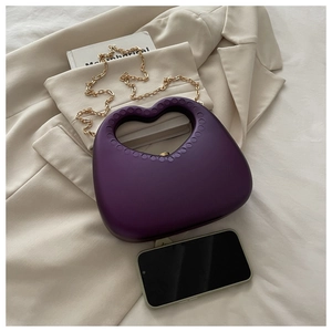 Detail view of purple heart evening bag capacity compared with a smartphone