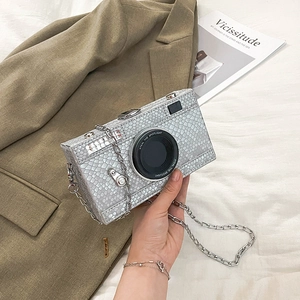 Detailed view of silver snake-pattern camera-shaped crossbody bag with metal chain strap