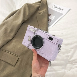 Detail of lavender snake-texture camera bag with silver chain and lens decoration