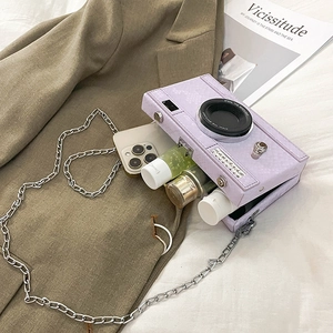 Macro view of purple camera-shaped crossbody bag showing internal storage capacity