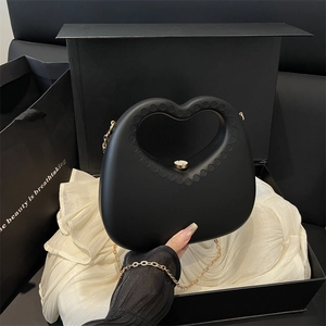 Chic black heart-shaped evening bag with gold chain strap in a premium gift box