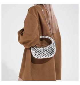 Détail du sac à main tissé argenté métallisé avec bandoulière chaîne sur manteau