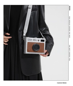 Detailed view of silver and brown leather vintage camera-shaped crossbody bag