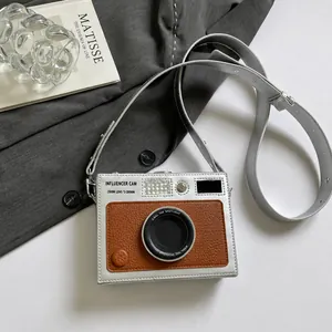 Detail shot of vintage camera-shaped crossbody bag with silver and brown leather panels