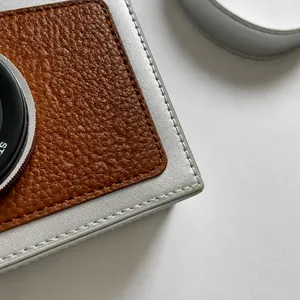 Detail of camera-shaped bag showing silver leather stitching and fine sewing craft