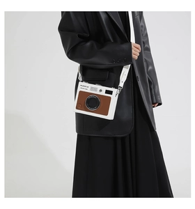 Detail of creative vintage camera crossbody bag with silver buckles on leather coat model