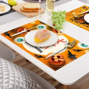 Halloween placemats featuring pumpkin and ghost patterns on a white table setting