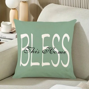 Housse de coussin vert sauge avec texte BLESS This Home sur un canapé de couleur crème