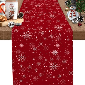 Chemin de table de Noël rouge avec flocons blancs sur une table décorée festive