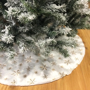 Dettaglio della gonna per albero di Natale in peluche bianco con fiocchi dorati