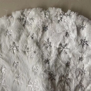 Dettaglio del tappeto per albero di Natale in peluche bianco con paillettes argentate