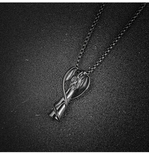 Detailed close-up of a gothic black angel wing pendant necklace with a sturdy box chain