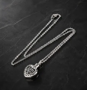 Macro view of heart-shaped stainless steel cremation urn pendant with Son engraving