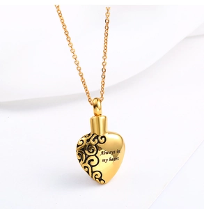 Detail of gold heart urn necklace engraved with Always in my heart and scroll patterns