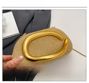Detail of woven straw evening bag with metallic C-shaped buckle and fine chain strap