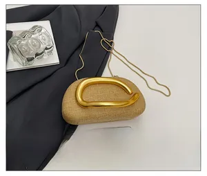 Mini acrylic woven crossbody bag with gold handle shown next to a smartphone for size scale