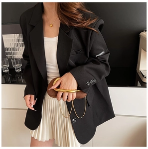 Detail of black tailored blazer cuff featuring a distinctive white woven brand label