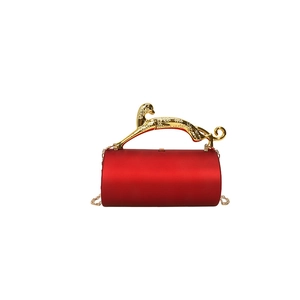 Elegant red silk cylinder handbag featuring a decorative gold panther handle and chain