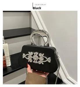 Detail of black box evening clutch with crystal floral decor and silver metal handle