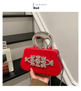 Detailed view of red box clutch bag with silver metal handle and crystal flower pattern