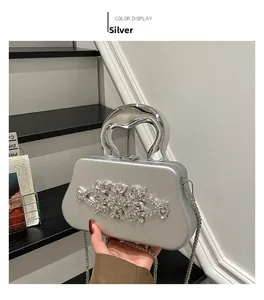 Detailed view of silver evening clutch featuring crystal floral patterns and metal handle