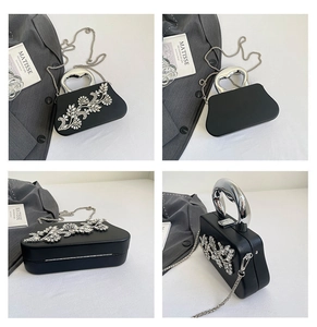 Macro view of crystal flower embellishments and metallic handle on the black evening bag
