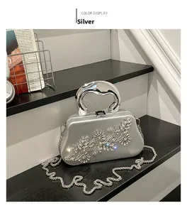 Macro shot of silver dinner clutch featuring sparkling rhinestone floral patterns and metal handle