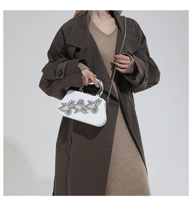 Detailed view of white crystal floral evening bag styled with a stylish beige dress outfit