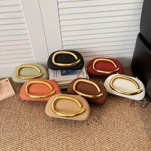 Chic woven handbags in multiple colors with bold gold metal handles and chain straps